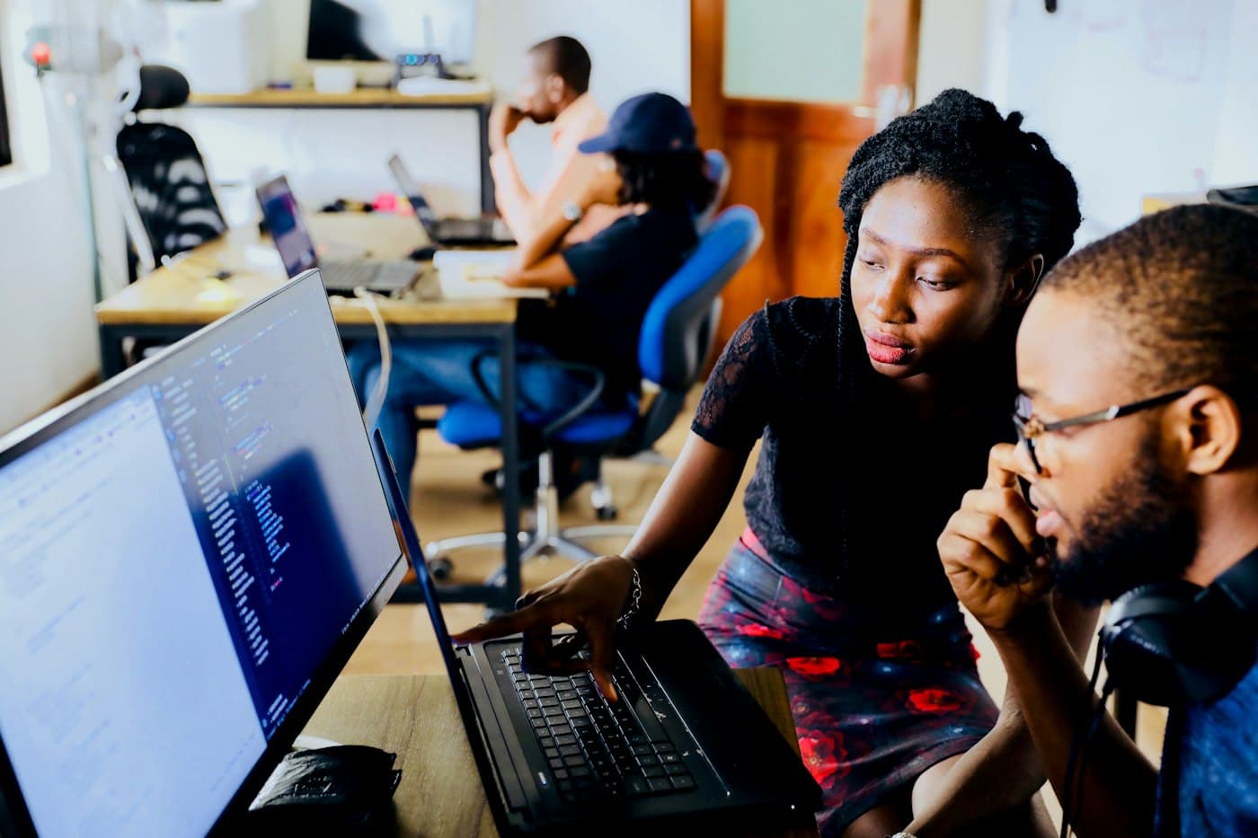Two founders working through a problem together at a laptop